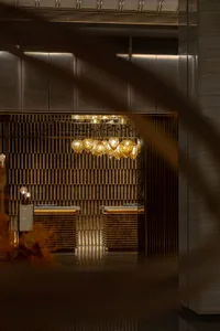 A stylish lobby featuring modern marble finishes and hanging light fixtures.