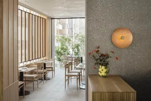 Modern restaurant interior showcasing contemporary design with wooden materials and sleek, minimalist decor.