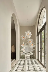 A minimalist corridor with white floral decor on a patterned tile floor.