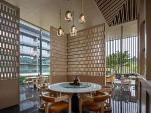 A modern restaurant interior features a combination of wood and glass materials.