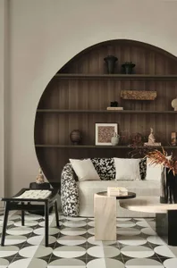 Modern living room with a round wooden shelf, a white sofa with black and white floral upholstery, and marble and concrete fu