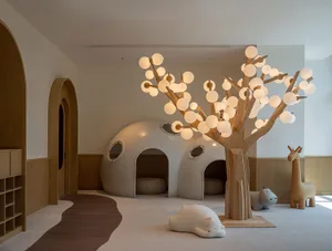A modern playroom featuring lighted wood and glass structures with white dome-shaped seating areas and soft, plush furniture.