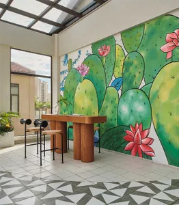 A modern cafe lobby featuring a vibrant botanical mural on the wall, with a tall wooden table and stools.