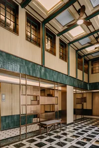 A modern lobby with green ceramic tiles, marble flooring, and wood accents.