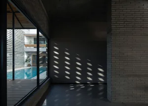 A minimalist interior featuring a brick and concrete art installation.