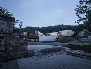 A modern minimalist landscape featuring stone, concrete, and glass.