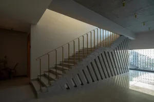 Staircase with concrete steps and yellow handrails in a modern architectural space.
