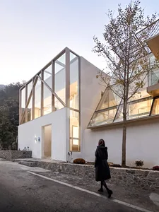 Modern building with large glass windows and white walls.