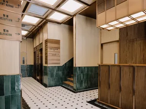 Modern hotel lobby with wooden panels and green tiled walls