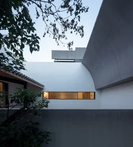 Modern residential building exterior with concrete walls and a geometric design.