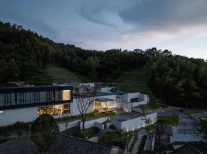 A modern house featuring concrete, glass, and stone exterior materials.