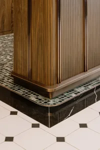 Modern kitchen with wooden cabinets, marble floor, and tiled accents.