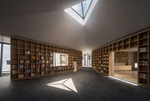 現代圖書館室內，木質書架與天窗