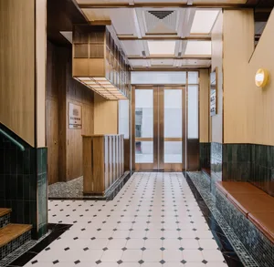 A modern lobby area featuring concrete, glass, and wooden elements.