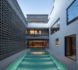 A modern residential interior with a concrete swimming pool and timber features.