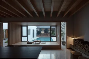 A modern residential space featuring a wooden interior with a pool and large windows.