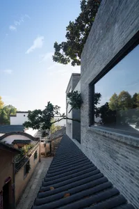 Street view featuring a modern building with brick exterior and large glass windows.