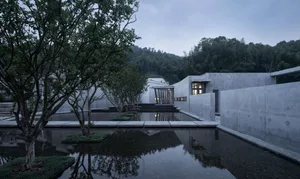 A minimalist landscape featuring concrete walls and a serene body of water.