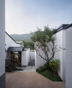 Minimalist residential exterior with concrete façade and wooden accents.