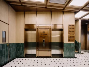 Modern hotel lobby featuring wood paneling and green tile floor.