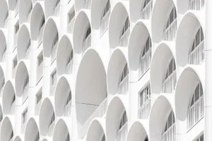Modern facade featuring repeated circular arches in stucco exterior