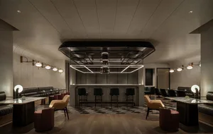 An industrial-style bar made of concrete with seating and lighting fixtures.