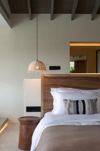 Modern, minimalist bedroom featuring a wooden headboard and textured blanket.