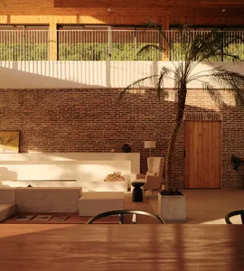 A modern living room with exposed brick walls, wooden furniture, and a potted palm plant.