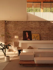Industrial living room featuring a brick wall and concrete floor.
