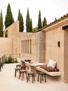 A minimalist outdoor seating area with concrete furniture and stools.