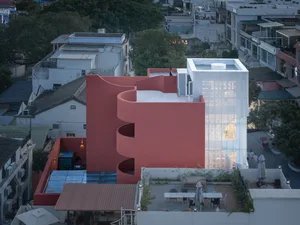 A modern building with a red exterior made of concrete.