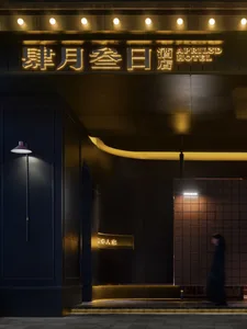 A modern hotel entryway featuring metallic lighting and concrete tiles.