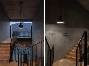 Interior design featuring modern hotel lobby with concrete walls and stairs.