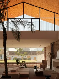 A modern interior featuring a living room with wood, glass, and brick elements.