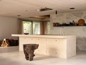 A modern kitchen featuring a concrete island and minimalist design.