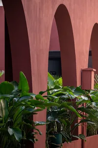 Red concrete architectural columns with green plants