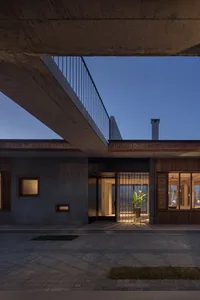 Modern residential house with concrete exterior and illuminated entrance.