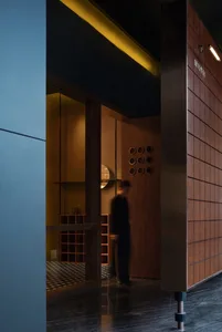 A modern restaurant interior with wooden elements, featuring a dark, sleek design with a focus on minimalist aesthetics and a