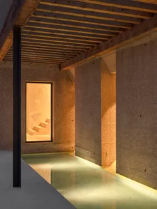 現代水療空間，混凝土牆面與地板，柔和燈光照亮室內，並設有游泳池。