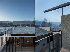 A stone-roofed balcony overlooking a mountainous landscape at dusk.