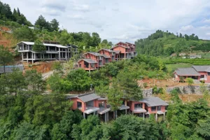 Multiple residential buildings nestled among greenery and hills