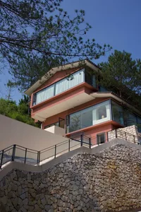 A modern residential building with concrete foundation and glass windows.