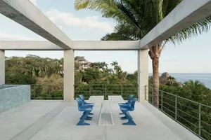 Minimalist patio featuring modern concrete and metal seating and table.