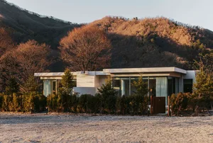 Modern house with concrete and glass materials on the exterior.