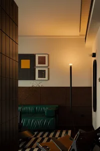 Modern living room with green leather sofa, striped rug, and floor lamp.
