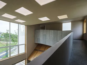 Modern minimalist interior design featuring a corridor with concrete and wood elements.