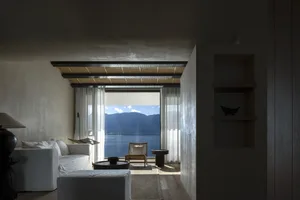 簡約風格客廳設有大型落地窗，窗外可見壯麗山景與湖泊。