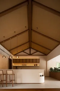 A minimalist bar counter space featuring a wooden counter, cabinets, and modern lighting.