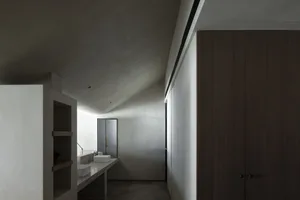 A modern minimalist bathroom with concrete finishes and wooden elements.