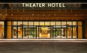 Modern building with glass and wooden materials and illuminated signage.